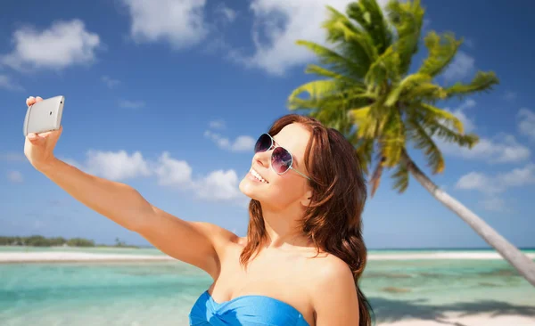 Frau macht Selfie mit Smartphone am Strand — Stockfoto