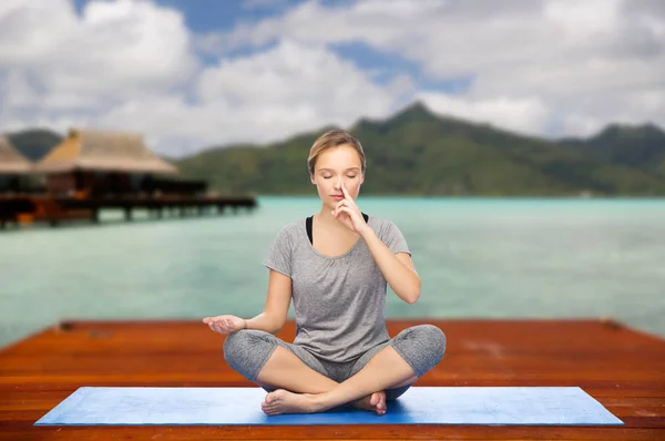 Женщина делает йогу и медитирует в позе лотоса — стоковое фото