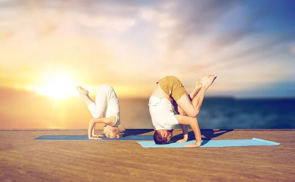 Yoga başı açık havada yapıyor Çift — Stok fotoğraf