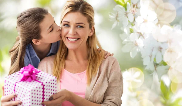 Daughter kissing mother and giving her present — Stock Photo, Image