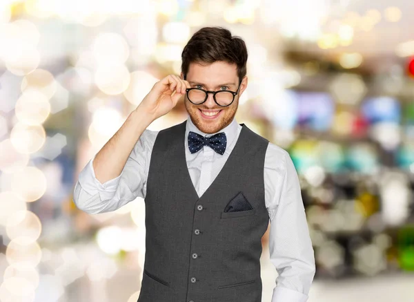 Happy man in suit and eyeglasses over lights — Stock Photo, Image
