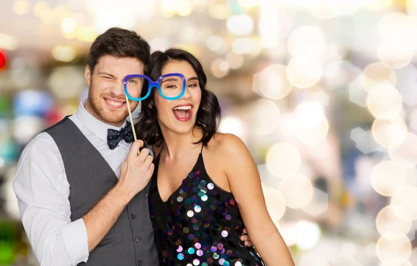 Glückliches Paar mit Partybrille über Lichtern — Stockfoto