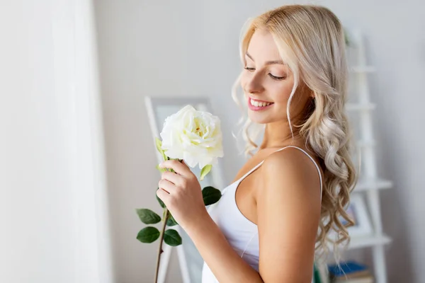 Mulher em roupa interior com flor de rosa na janela — Fotografia de Stock