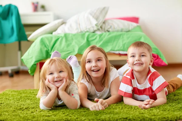 Glückliche kleine Kinder, die auf dem Boden oder Teppich liegen — Stockfoto