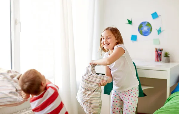Kids playing and fighting by pillows at home — Stock Photo, Image