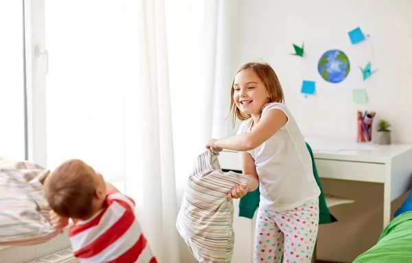 Niños jugando y luchando por almohadas en casa —  Fotos de Stock