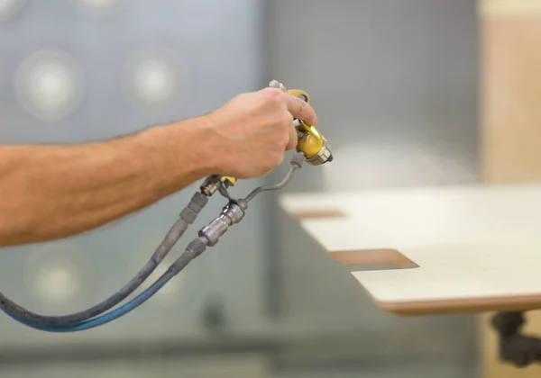 Robotnik ręka spraye lakier do płyty — Zdjęcie stockowe
