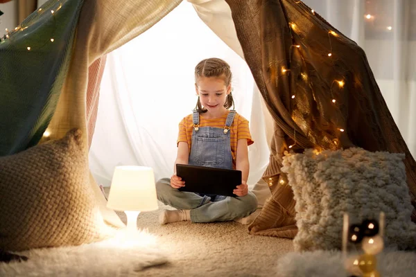 Bambina con tablet pc in tenda per bambini a casa — Foto Stock