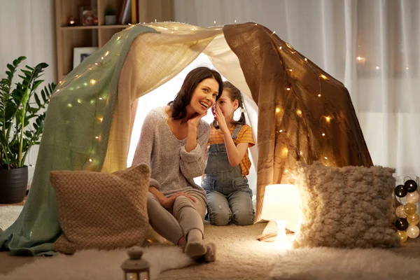 Família feliz sussurrando na tenda crianças em casa — Fotografia de Stock