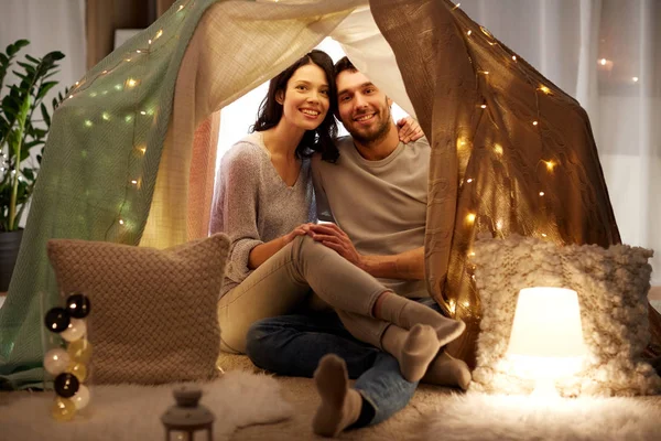 Lyckliga par i barn tält hemma — Stockfoto