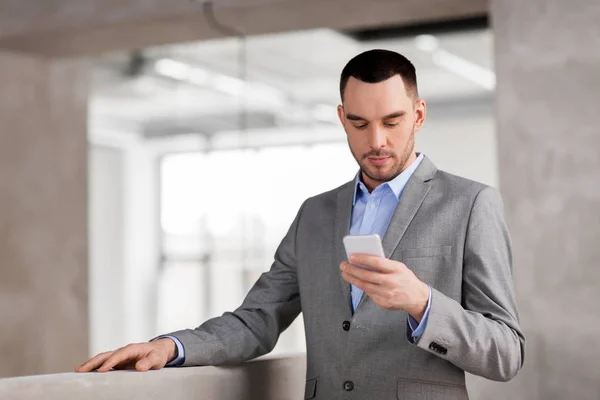 Affärsman med smarphone på kontor — Stockfoto