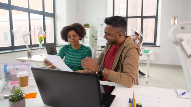 Trabajadores creativos discutiendo papeles en la oficina — Vídeo de stock
