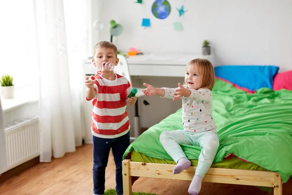 Enfants soufflant des bulles de savon et jouant à la maison — Photo