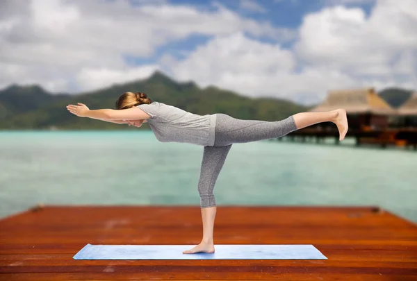 Vrouw maken yoga warrior pose op de mat buitenshuis — Stockfoto