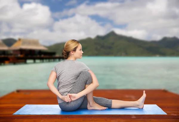 Женщина делает йогу в позу твиста на открытом воздухе — стоковое фото