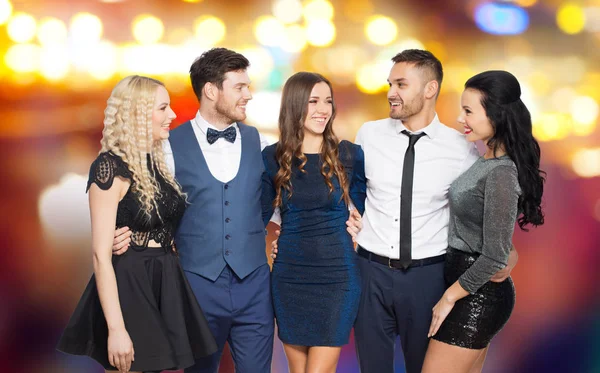 Amigos felizes em roupas de festa abraçando — Fotografia de Stock