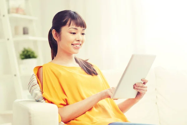 Glad ung asiatisk kvinna med TabletPC hemma — Stockfoto