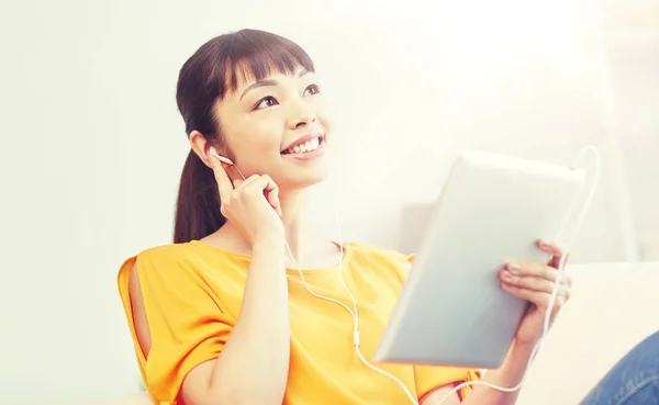 Feliz mulher asiática com tablet pc e fones de ouvido — Fotografia de Stock