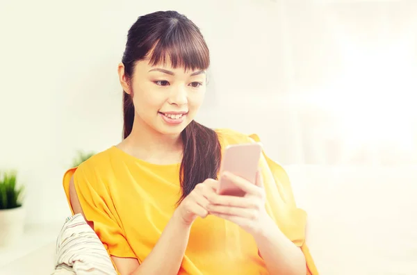 Mujer asiática feliz con smartphone en casa —  Fotos de Stock