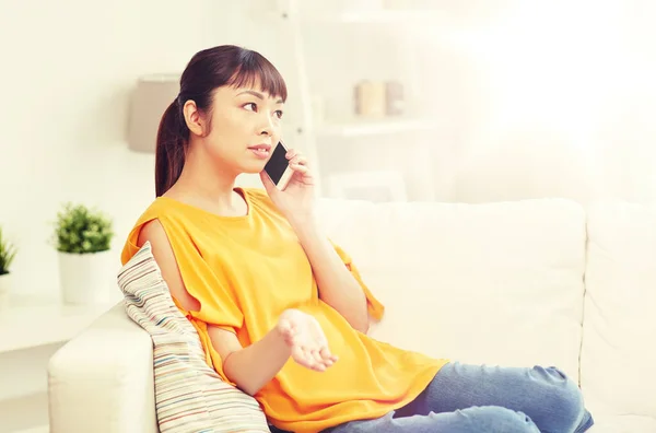Junge Asiatin telefoniert zu Hause mit dem Smartphone — Stockfoto