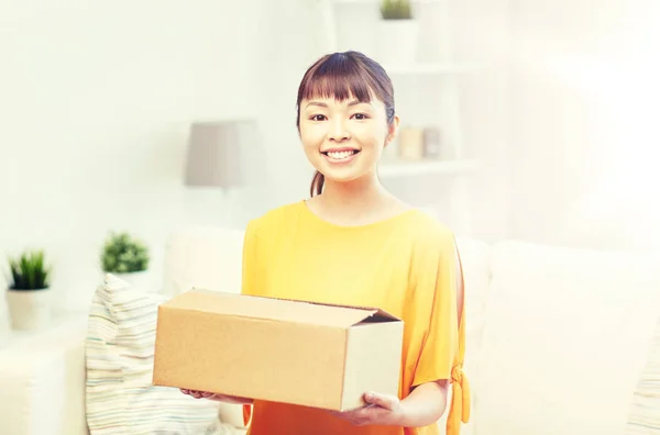 Evinde paket kutusu olan mutlu Asyalı genç bir kadın. — Stok fotoğraf