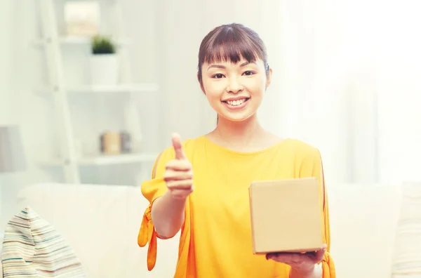 Happy asian young woman with parcel box at home — Stock Photo, Image