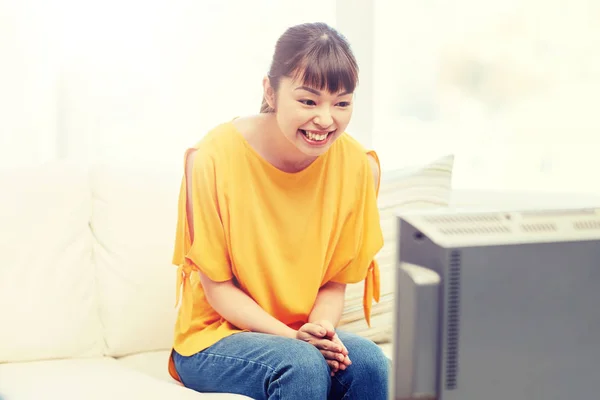 Happy asian young woman watching tv at home — Stock Photo, Image