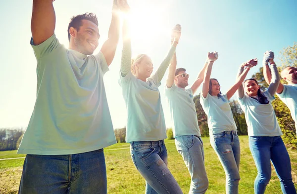 Gruppe von glücklichen Freiwilligen, die sich im Freien die Hände reichen — Stockfoto