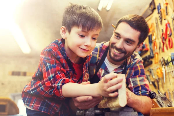 Pappa och Lille son med trä planka på verkstad — Stockfoto