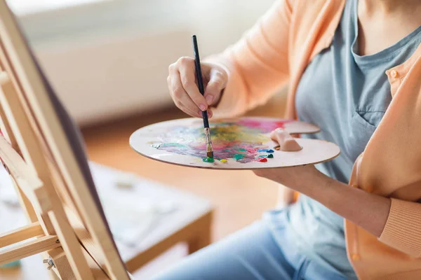 Artista com paleta e pintura pincel no estúdio — Fotografia de Stock