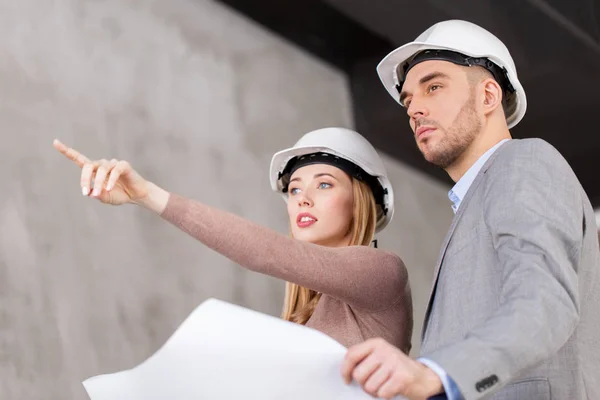 Architects in helmets with blueprint — Stock Photo, Image