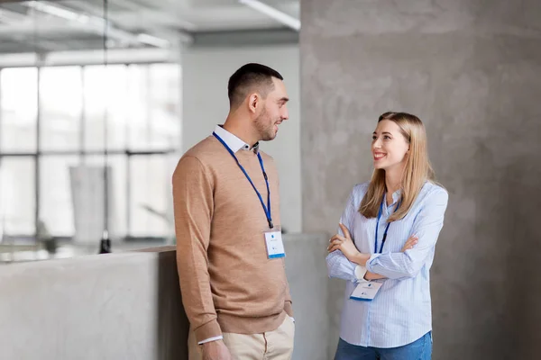 Hombre y mujer con placas de conferencia en la oficina — Foto de Stock