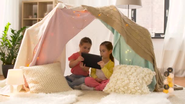 Маленькие девочки с планшетным ПК в детской палатке дома — стоковое видео