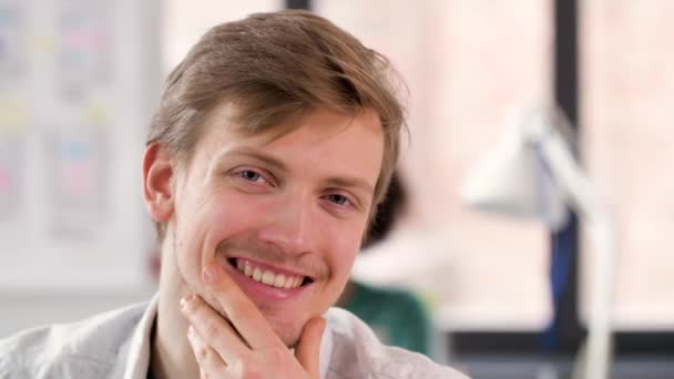 Портрет счастливого улыбающегося молодого человека в офисе — стоковое видео