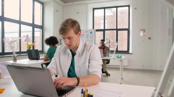 Kreativa manliga kontorsarbetare att skriva på laptop — Stockvideo