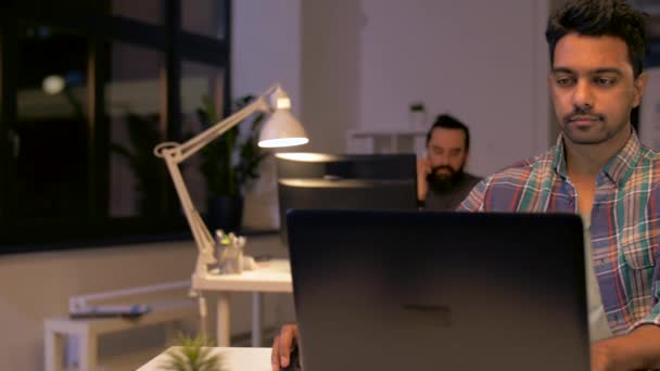 Creatieve man met laptop werken op kantoor van de nacht — Stockvideo
