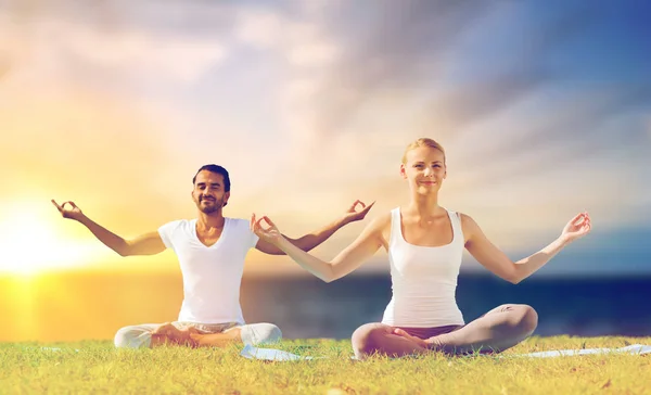 Casal feliz fazendo ioga e meditando ao ar livre — Fotografia de Stock