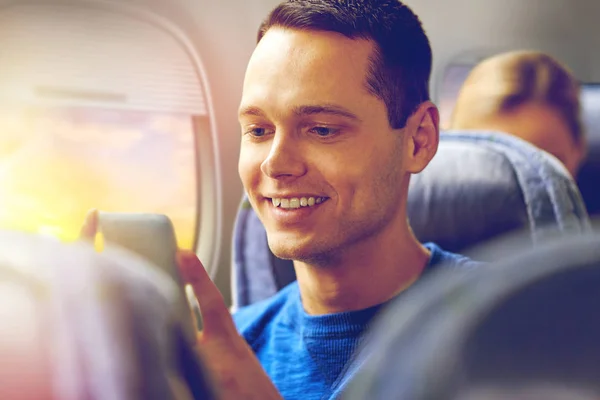 Hombre feliz sentado en avión con teléfono inteligente — Foto de Stock