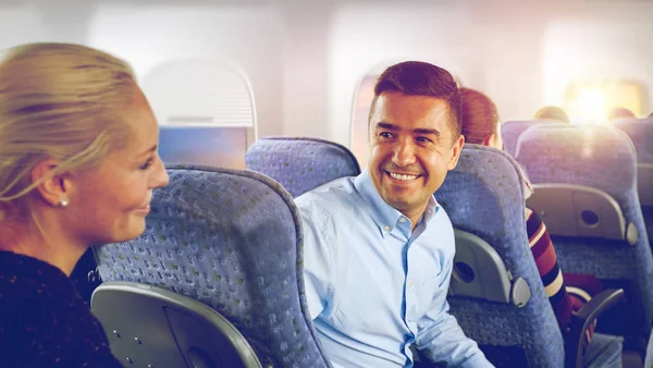 Pasajeros felices hablando en avión — Foto de Stock