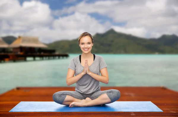 Женщина делает йогу и медитирует в позе лотоса — стоковое фото