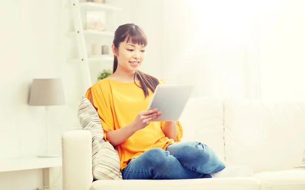 Feliz jovem mulher asiática com tablet pc em casa — Fotografia de Stock