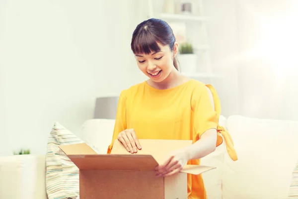 Gelukkig aziatische jong vrouw met pakket doos thuis — Stockfoto