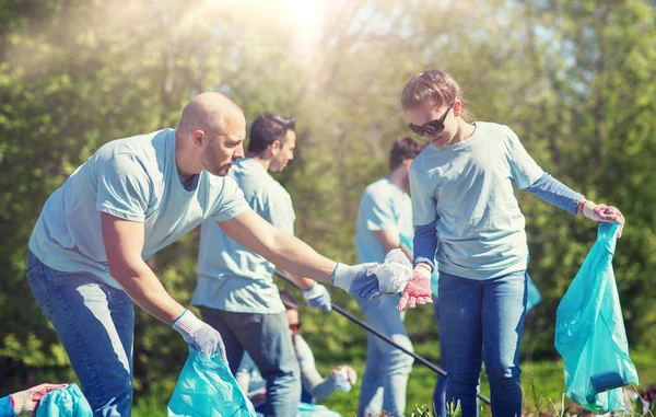 Voluntarios con bolsas de basura limpieza área del parque — Foto de Stock