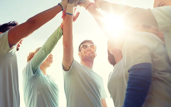 Group of volunteers making high five outdoors — Stock Photo, Image
