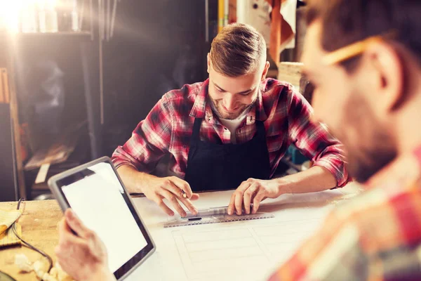 Arbeiders met tablet pc en blauwdruk op workshop — Stockfoto