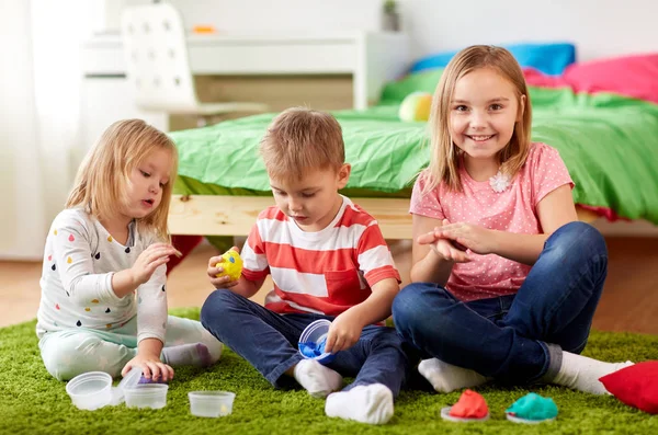 Kids with modelling clay or slimes at home — Stock Photo, Image