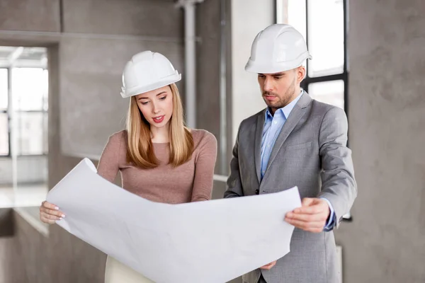 Architects with blueprint and helmets at office — Stock Photo, Image