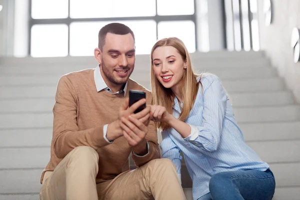 Mann und Frau mit Smartphone auf Bürotreppe — Stockfoto