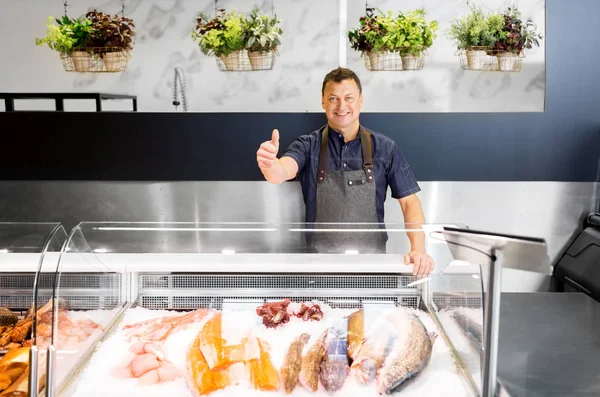 Fischverkäufer im Fischladen zeigt Daumen hoch — Stockfoto