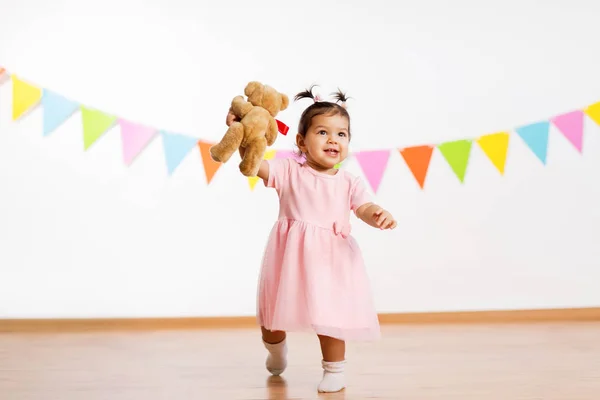 Happy baby girl with teddy bear on birthday party — Stock Photo, Image